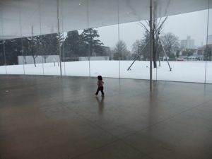 金沢21世紀美術館 行きの背景の前で美術館のなかで走る真由喜