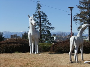 公園で白馬の彫刻と背景に丹沢の上に覗く富士山
