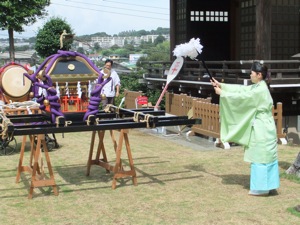 女性の神職が神輿を祓う