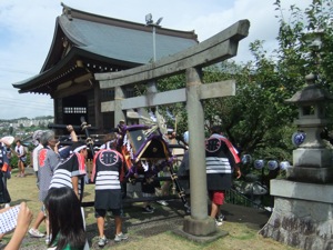 お神輿と鳥居 傾けたお神輿を鳥居を通らせる