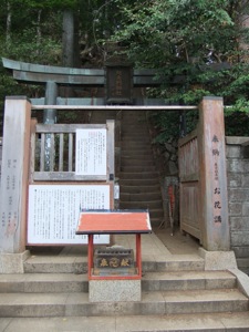 門の後ろに銅製の鳥居がある参道の入り口