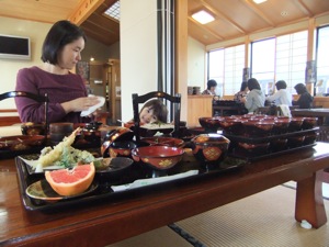 手前にはわんこそばが並ぶが、食器の柄の間に真由喜の顔が見える