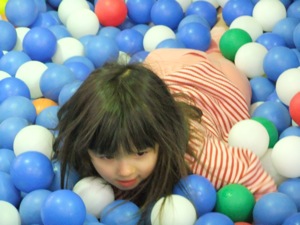 真由喜がボールプールで泳いでいる。