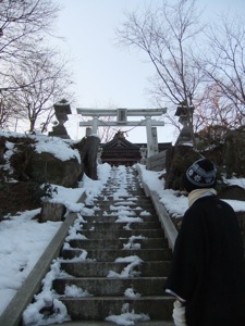 雪のある石段の上、鳥居と社殿