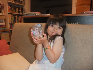 真由喜がダンゴムシが入る瓶を持つ