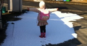 真由喜が雪の端で立って、腕を広げる