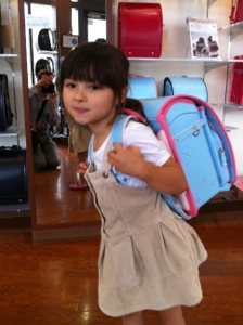 真由喜が水色のピンクふちのランドセルを背負う