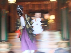 御幣を持っている宮司さんが黒い仮面をして舞う