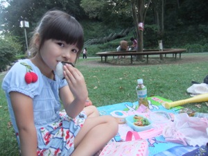 真由喜が公園でおにぎりを食べる