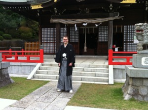 私が紋付羽織袴で白幡八幡大神の社殿の前に立つ