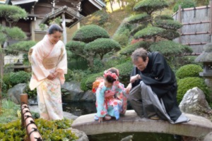 三人は着物姿で、日本庭園の石橋の上に揃う