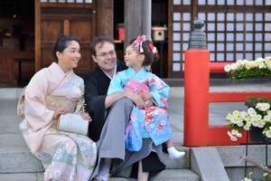 三人で着物姿で神社の石段に座って