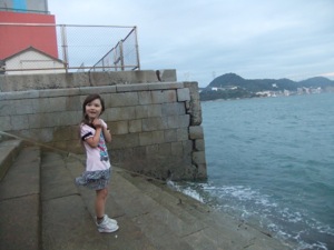 海に降りる階段に立つ真由喜