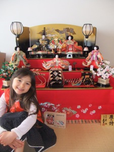 真由喜がお雛様の三段飾りの前に座る